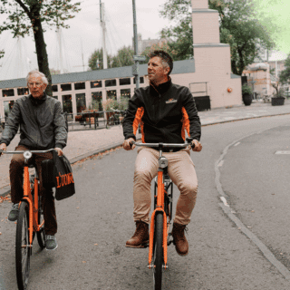 Ondernemer en ondernemerscoach fietsen door verschillende steden